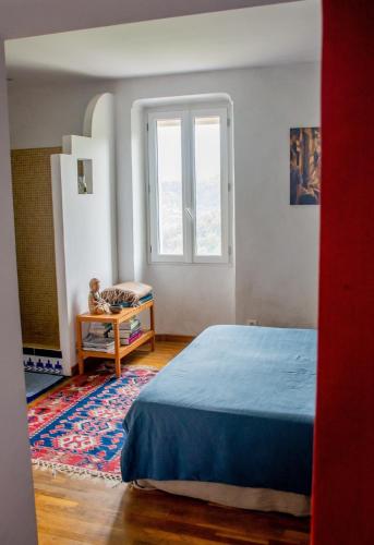 une chambre avec un lit et une fenêtre dans l'établissement Village house surrounded by greenery, à La Gaude