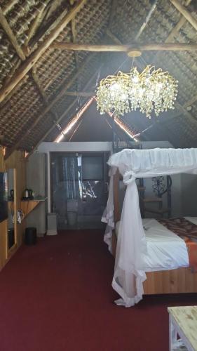a bedroom with a bed and a chandelier at The Giraffe Cottages in Nairobi