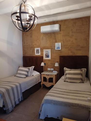 a bedroom with two beds and a chandelier at El Cortijo Hotel Boutique in Cachí