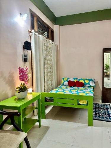 a room with a green bench and a table at M G Guest House in Dispur