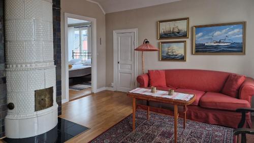 a living room with a red couch and a table at Trea centralt Västervik in Västervik