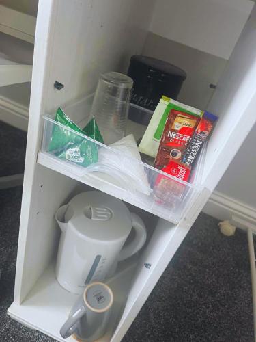 a white shelf with food and other items on it at Ensuite Private Cosy Space Near the Bus Station in Broughton