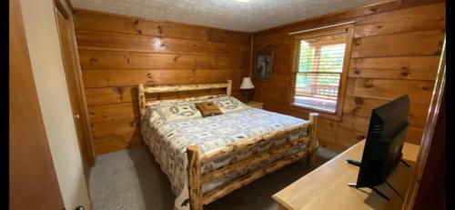 a bedroom with a bed and a desk with a television at Mountain Laurel in Sevierville