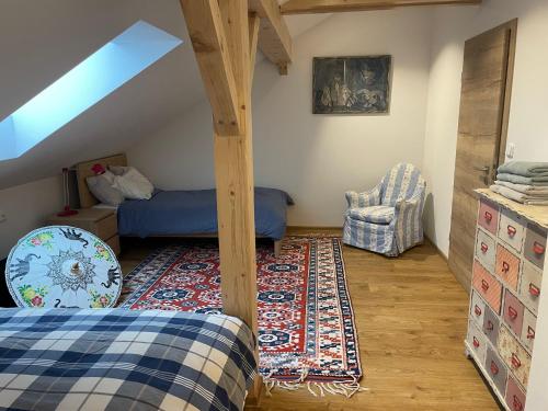 a attic bedroom with a bed and a rug at Apartmán na úpatí Šumavy in Stachy