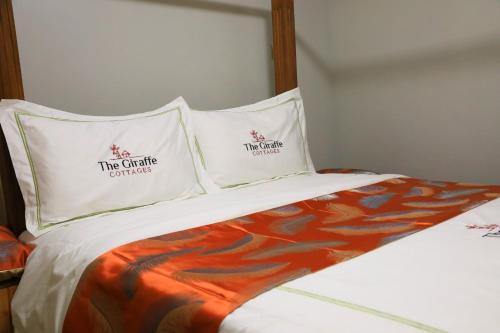 a bed with two pillows with the criteria on it at The Giraffe Cottages in Nairobi