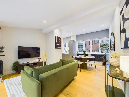 a living room with a green couch and a table at Be London - The Piccadilly Circus Residences in London