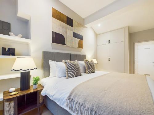 a bedroom with a large bed and a lamp at Be London - The Piccadilly Circus Residences in London