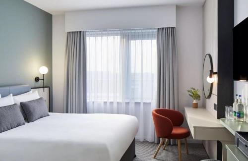 a hotel room with a bed and a desk at Leonardo Hotel Dublin Parnell Street in Dublin