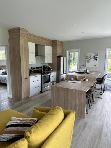 a kitchen with a table and a yellow couch at Kabin Kamouraska 1 in Rivière-Ouelle