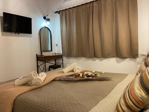 a bedroom with a bed with towels and a mirror at Daphne Studios in Tsilivi
