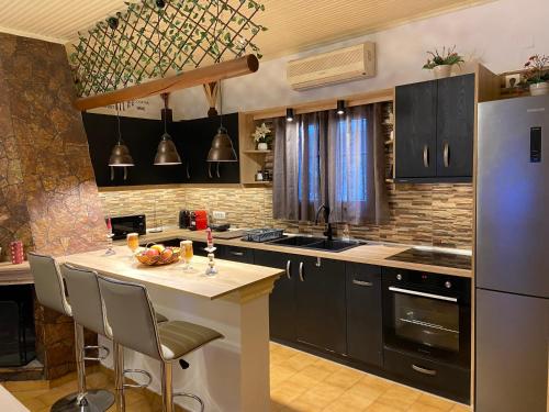 a kitchen with black cabinets and a white counter top at Daphne Studios in Tsilivi
