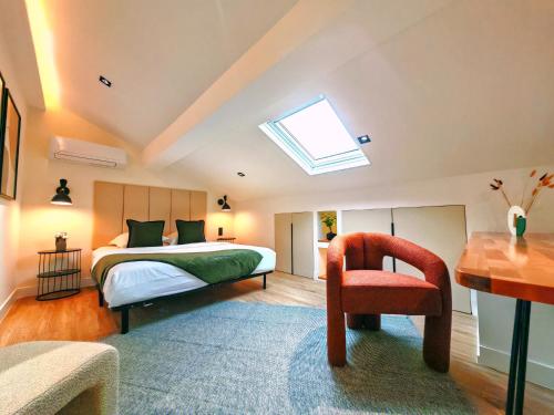 a bedroom with a bed and a chair and a skylight at L'Escapade Bord de Mer - 3 Pieces - GOLFE JUAN in Vallauris