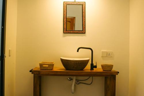 a bathroom with a bowl sink and a mirror at Hakuna in Arusha