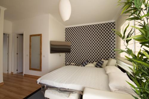 Un dormitorio con una cama blanca y un sofá. en Luxury Europe, en Puerto de Mogán
