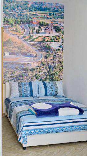 a bedroom with a bed with a painting on the wall at Apartments Pravica Trebinje in Trebinje
