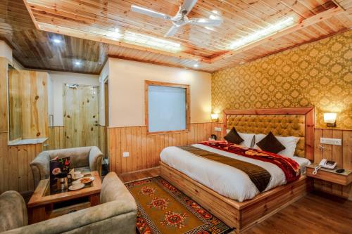 a bedroom with a bed and a couch and a chair at HUKAM'S HOLIDAY HOME by HHH in Kasol