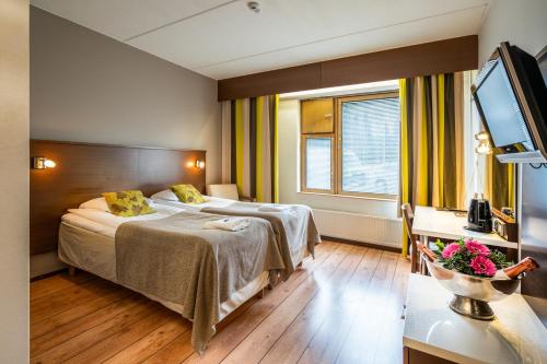 a hotel room with a bed and a television at Hotel Kurikka in Kurikka