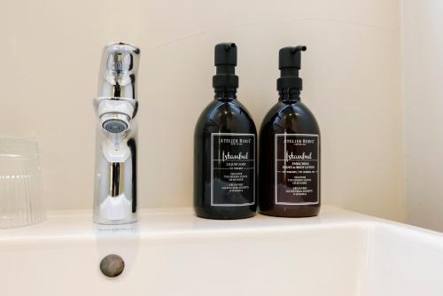 three bottles of alcohol sitting on a shelf in a bathroom at Hotel Bloemendaal by BHC in Bloemendaal
