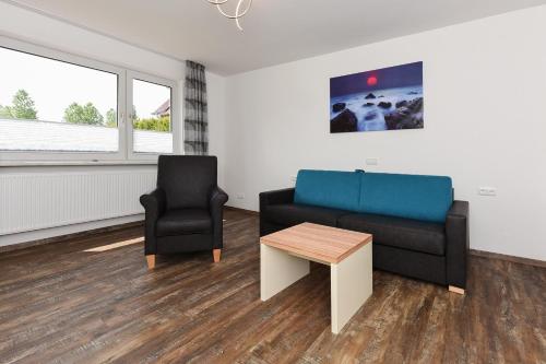 a living room with a couch and a chair at Zur Möwe 5 in Esens