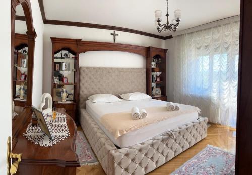 a bedroom with a large bed and a table and a desk at Kuća za odmor ''ANA'' in Čitluk