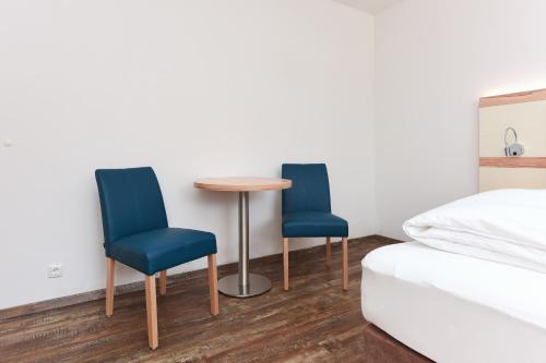 two blue chairs and a table in a bedroom at Zur Möwe 5 in Esens