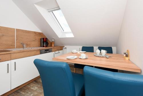 a kitchen with a wooden table and blue chairs at Zur Möwe 4 in Esens