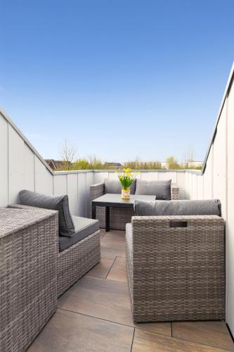 a patio with wicker furniture and a table at Zur Möwe 4 in Esens