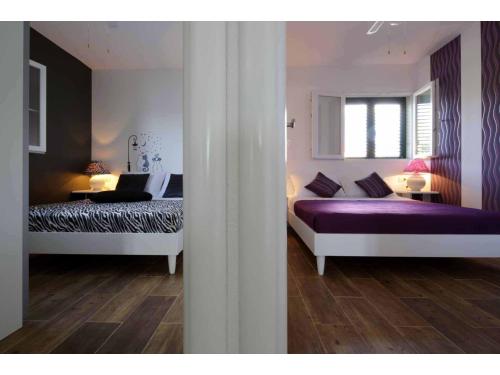 a bedroom with two beds and a window at Apartments Elda in Makarska