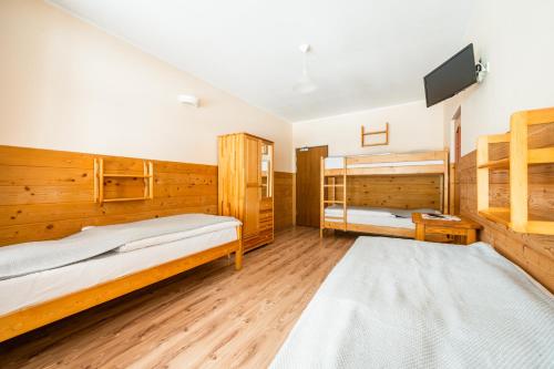 a bedroom with two beds and a flat screen tv at Schronisko PTTK Orlica in Szczawnica