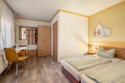 a hotel room with two beds and a desk at Pension Ufert in Meißen