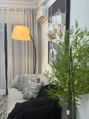 a living room with a couch and a lamp at Appartement meublé type F2 in Douala