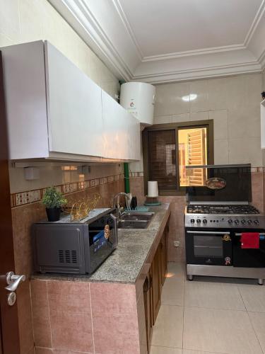 a kitchen with a microwave and a stove at Appartement meublé type F2 in Douala