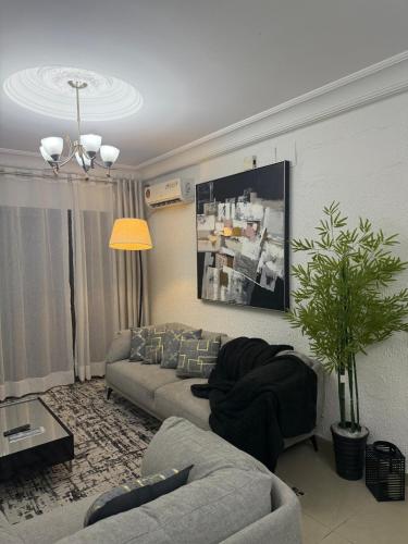 a living room with a couch and a table and a tv at Appartement meublé type F2 in Douala