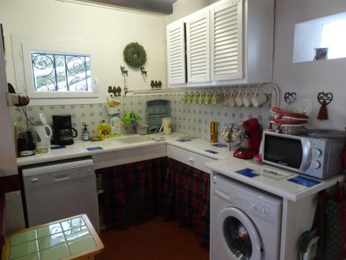 une cuisine avec un évier et une machine à laver dans l'établissement Chalet avec vue panoramique sur le Plomb du Cantal, à Saint-Jacques-des-Blats