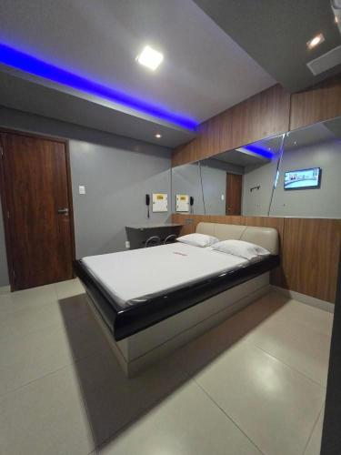 萨尔瓦多Hotel Alfama Motel的一间卧室配有一张蓝色灯的大床