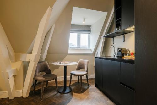a small kitchen with a table and two chairs at Hotel Bloemendaal by BHC in Bloemendaal