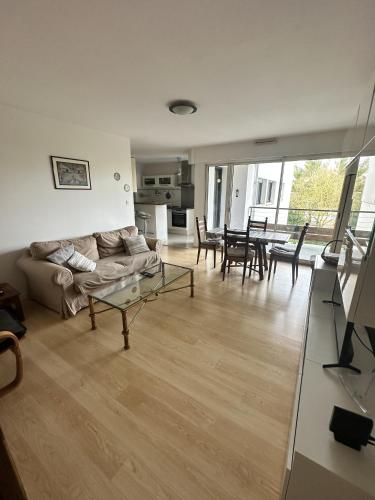 un salon avec un canapé et une table dans l'établissement Proche mer, terrasse et wifi, aux minimes, à La Rochelle