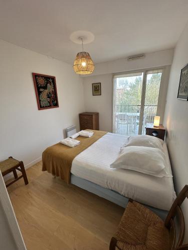 une chambre avec un grand lit et une fenêtre dans l'établissement Proche mer, terrasse et wifi, aux minimes, à La Rochelle