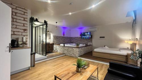 a living room with two beds and a table at SUITE LA SERENITA - JACUZZI - CLIM - WIFI - TopProsConciergerie in Saint-Georges-dʼOrques