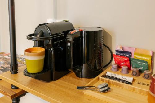 a coffee maker and a cup on a wooden table at Hotel Bloemendaal by BHC in Bloemendaal