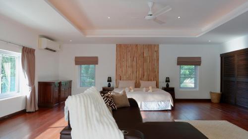 a large bedroom with a bed and a couch at Villa sun in Amphoe Koh Samui