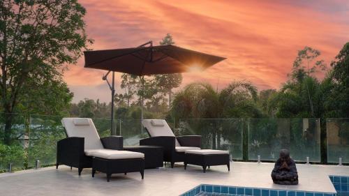 a group of chairs and an umbrella next to a pool at Villa sun in Amphoe Koh Samui