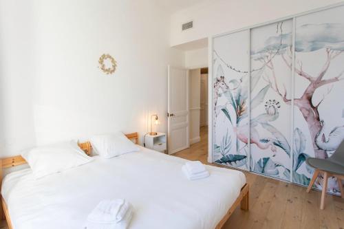 - une chambre avec un lit blanc et une fresque murale dans l'établissement #17 Suite Gioffredo 3 chbres air conditioning 5mins Vieux NicePort, à Nice