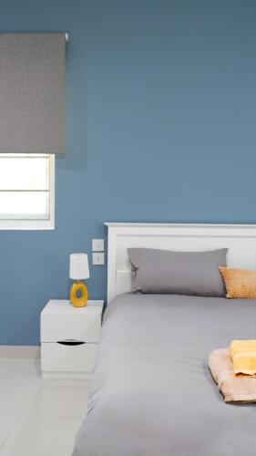 a bedroom with a large bed with a blue wall at Villa sun in Amphoe Koh Samui