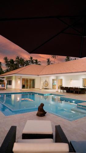 a teddy bear sitting in front of a swimming pool at Villa sun in Amphoe Koh Samui