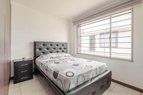 a bedroom with a bed and a window at Taz's house in Hacienda Yacucalle