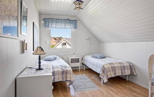 Un dormitorio con dos camas y una ventana. en Spacious house in the heart of Fjällbacka, en Fjällbacka