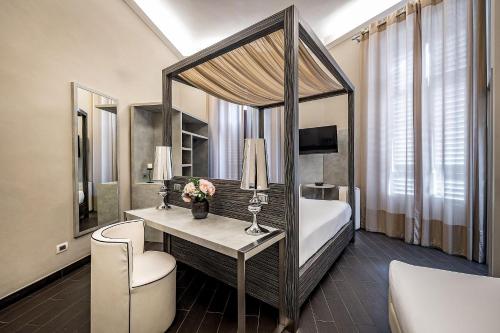 a hotel room with a bed and a desk with flowers at B&B Residenza le Fonticine in Florence