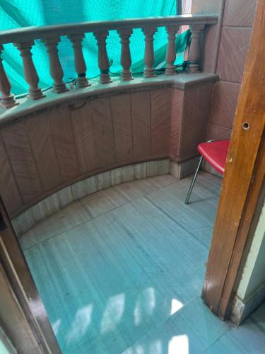 a balcony with a red chair and a blue curtain at SA HAVELi in Bikaner