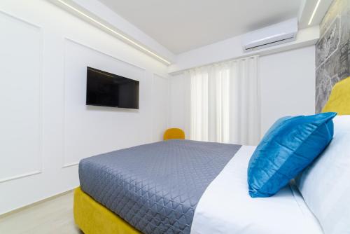 a bedroom with a bed with a blue pillow at Shamika Luxury Rooms in Pontecagnano